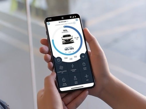2025 Nissan LEAF view of someone holding a smart phone with the Nissanconnect app pulled up