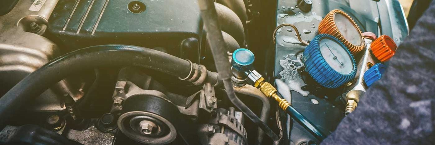 Close up view of gauges hooked up to a vehicle's ac component 